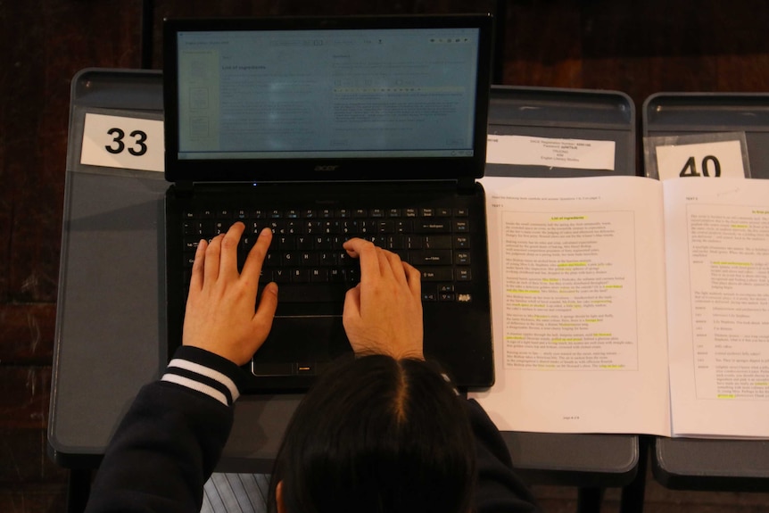 A student's hands on a laptop key.