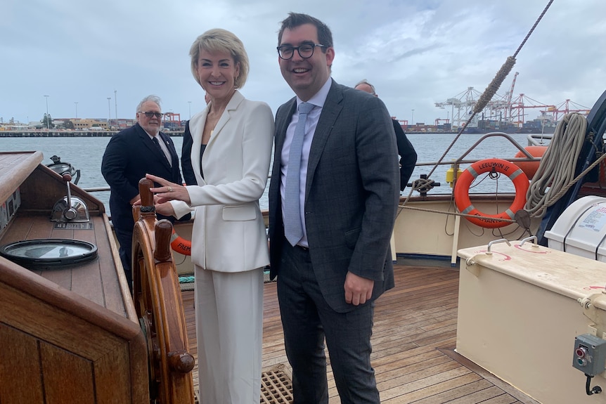 Michaelia Cash at the helm of a large boat, with Ben Small standing beside her.