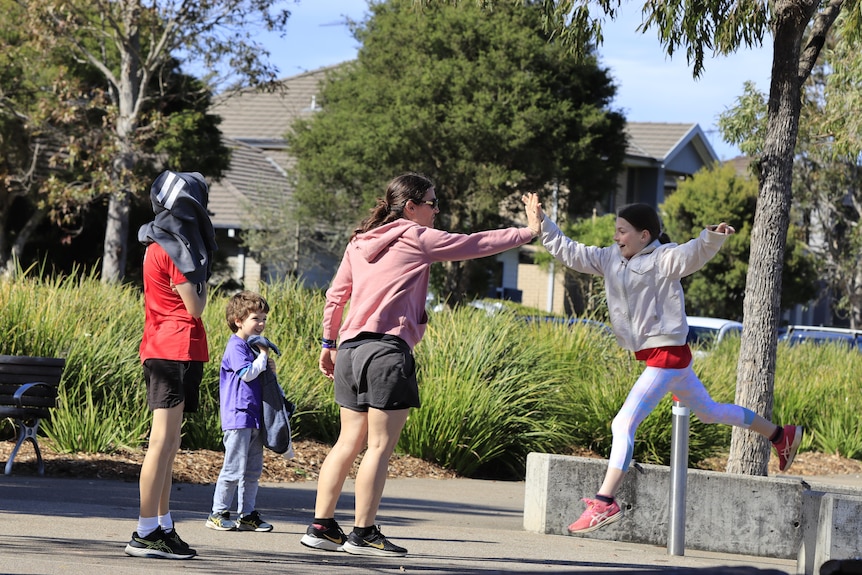 A woman high fives a child