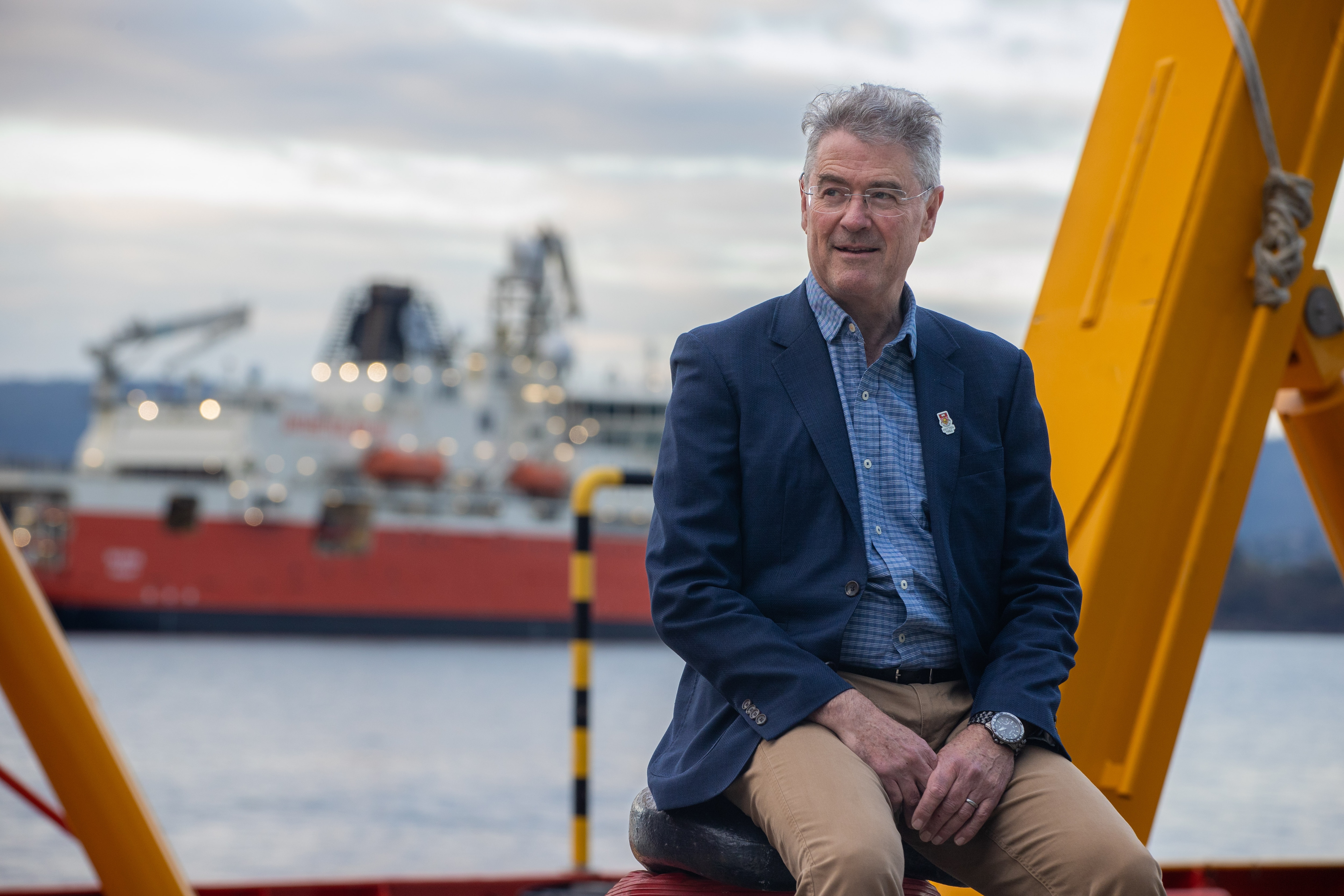 Un hombre con una chaqueta azul junto al agua.