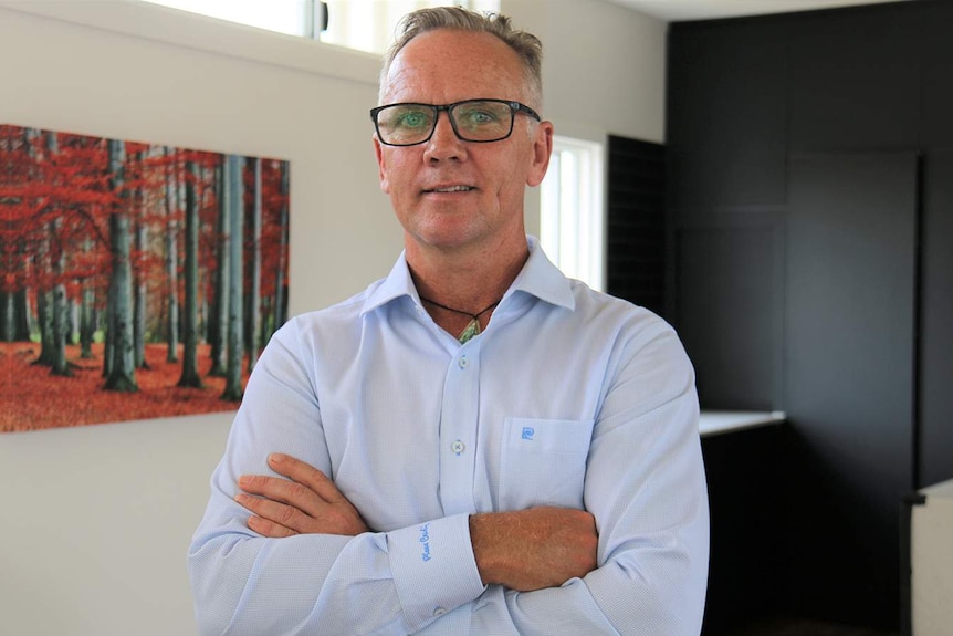 Grant Robin stands with arms crossed inside family unit at Logan House at Chambers Flat, south of Brisbane.