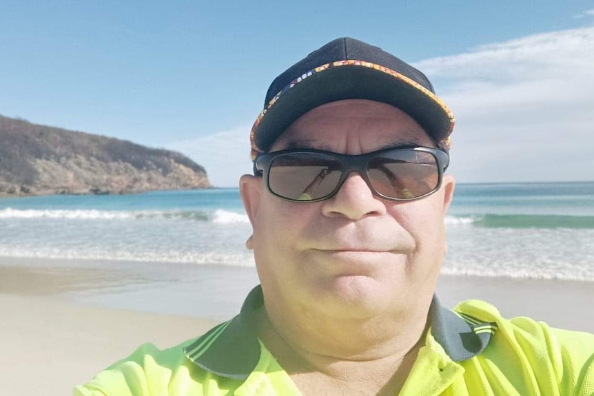 Thaua man, Steven Holmes standing on a beach.