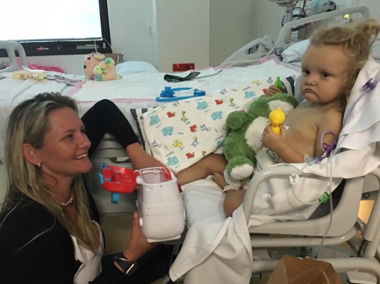 Harper in a hospital bed with her mother. 