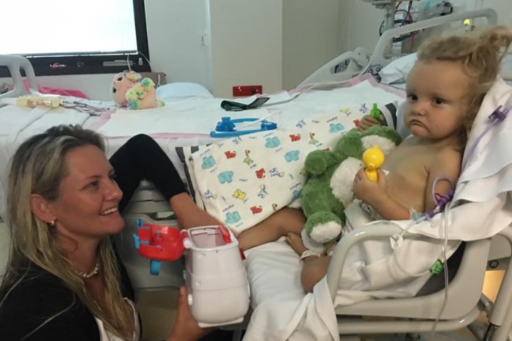 Harper in a hospital bed with her mother. 