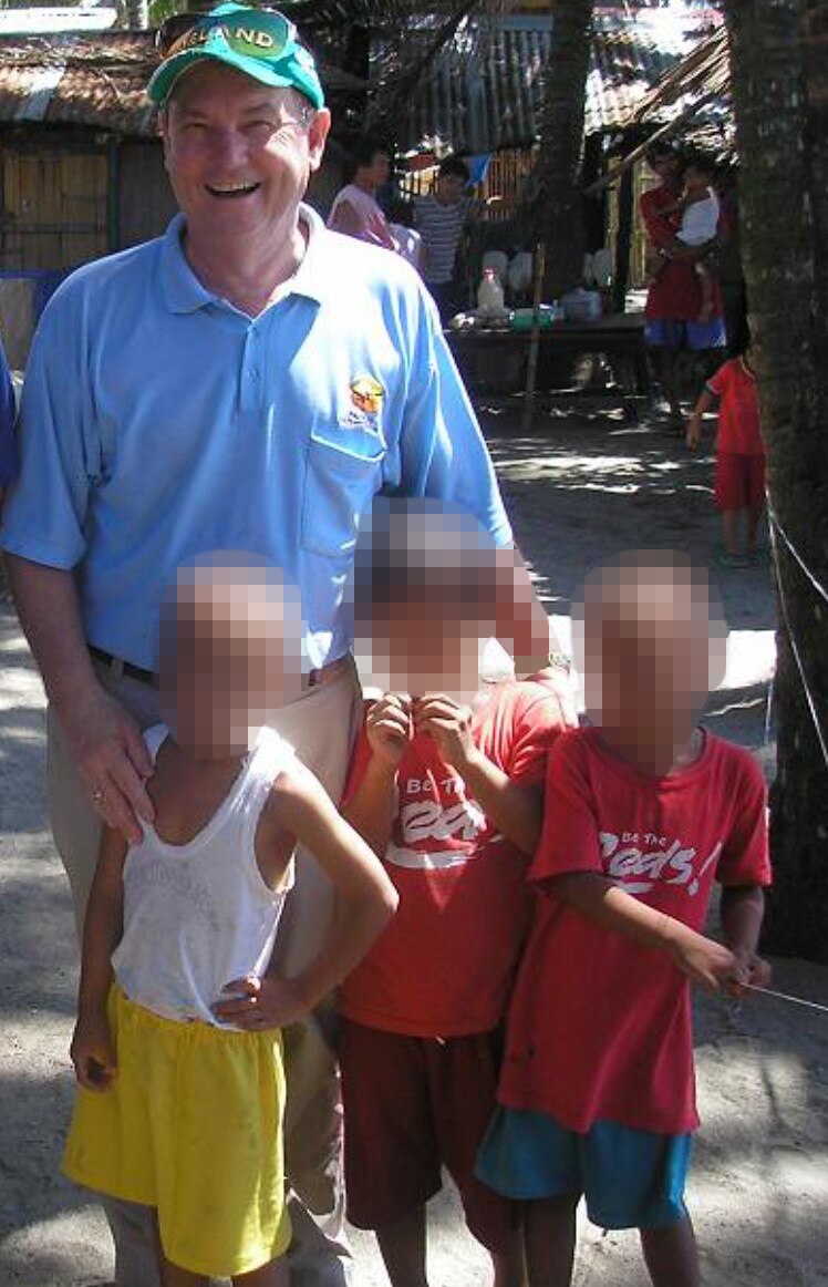 Stephen McLaughlin stands next to children in the Philippines.