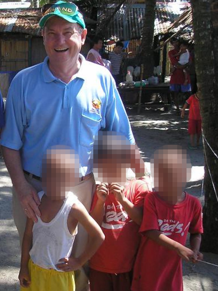 Stephen McLaughlin stands next to children in the Philippines.