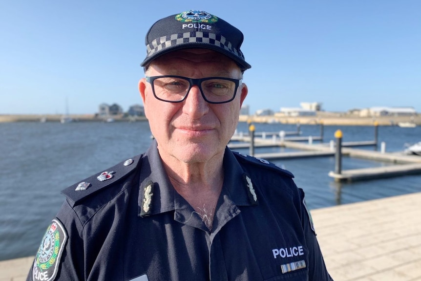 Police officer stands along South East coastline.