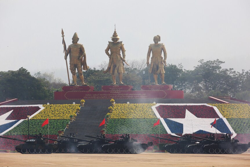 Tanks roll past three statues in Naypyitaw, Myanmar's captial.