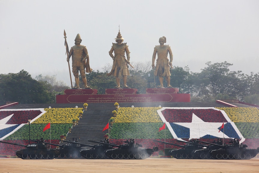 Tanks roll past three statues in Naypyitaw, Myanmar's captial.