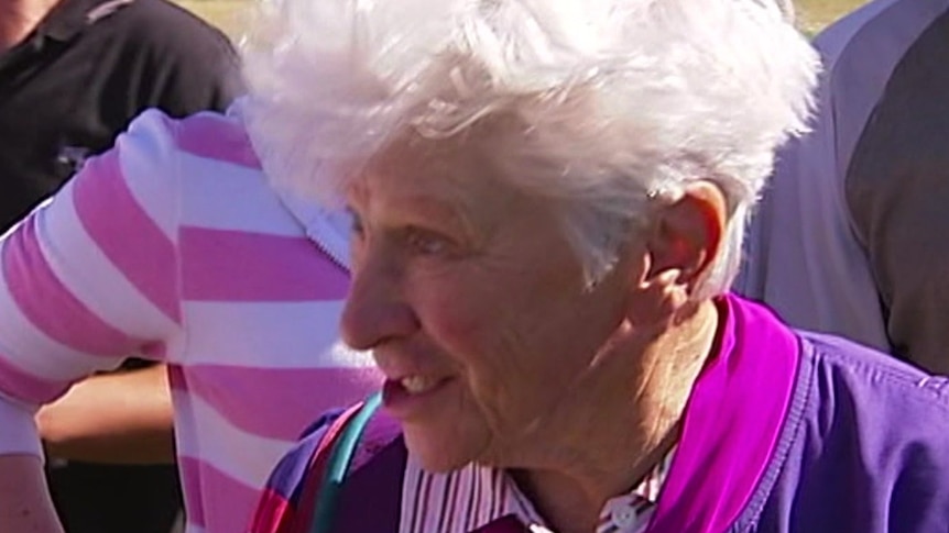 A smiling woman with white hair.