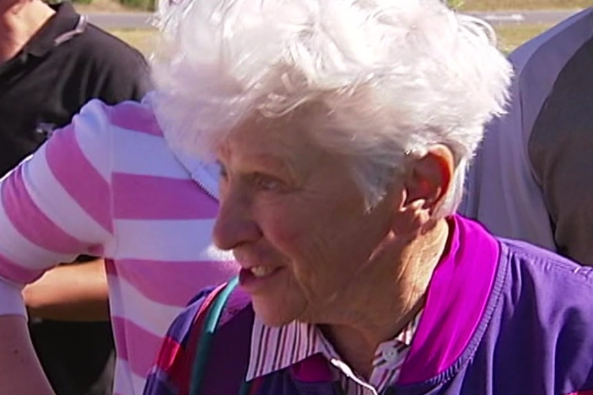 A smiling woman with white hair