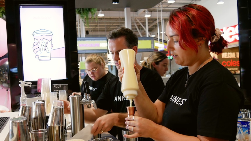 Three staff members make Vietnamese coffee.