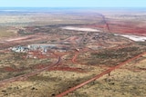 An aerial shot of the gold mine, surrounded by red dirt