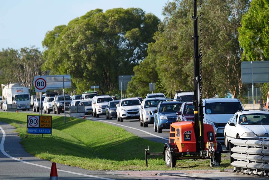 A queue of cars lined up along a dual carriage highway