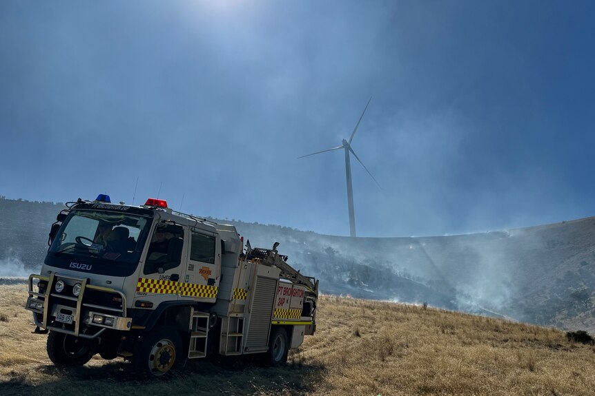 A fire truck with a wind turbine and smoke