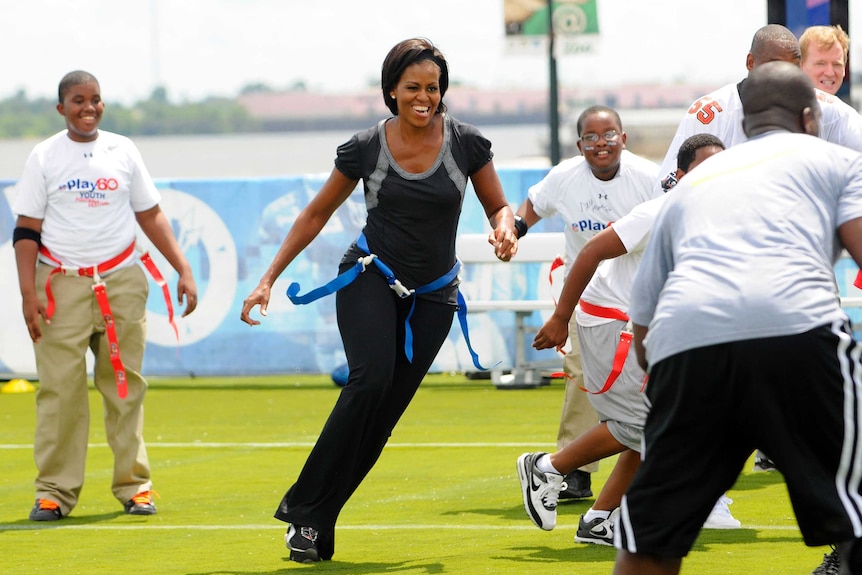 Michelle Obama jogs with children at a back-to-school event at Orr Elementary School in Washington