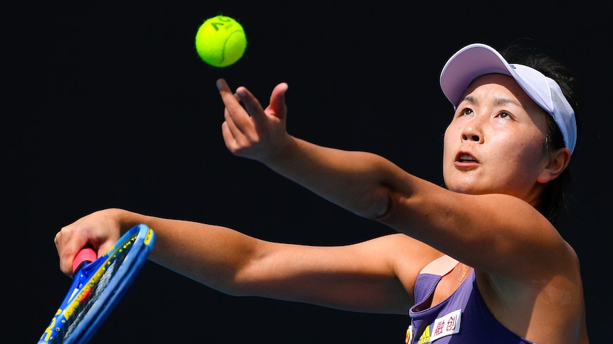 Tennis player Peng Shuai throws a tennis ball into the air