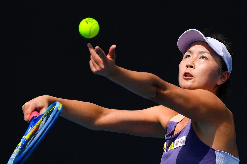 Tennis player Peng Shuai throws a tennis ball into the air