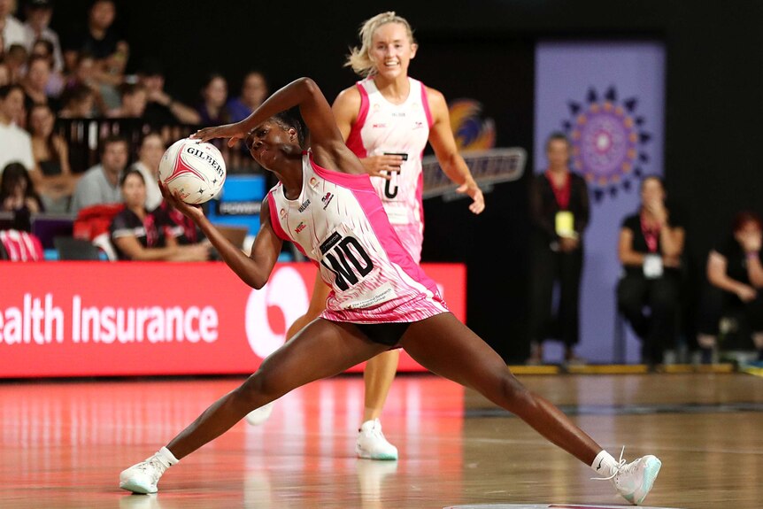 An Adelaide Thunderbirds Super Netball player holds the ball during a game against the Queensland Thunderbirds.