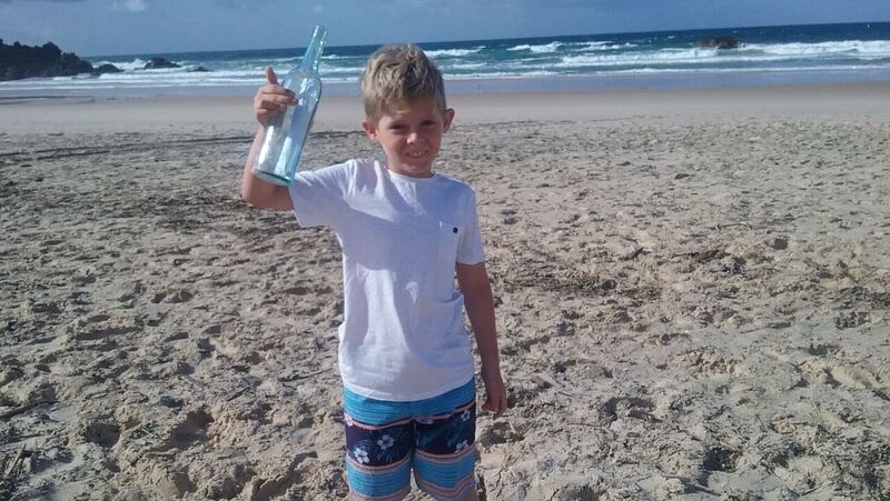 9 yo old Tristan Scilinato holding the bottle he found in the sand on Hungry Head beach.