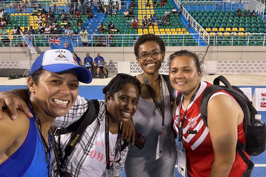 Four women taking a selfie at a sports arena