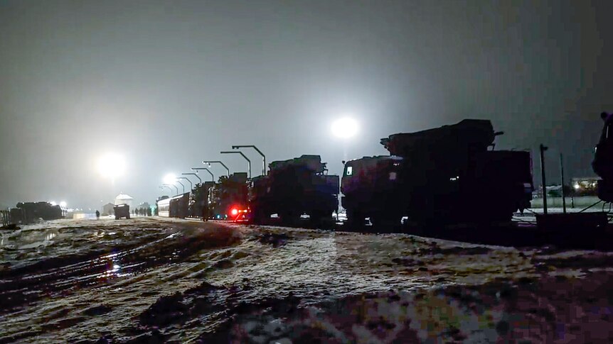 Russian military vehicles prepares to drive off a railway platforms after arrival in Belarus.