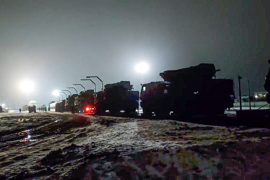 Российская военная техника готовится к выезду с железнодорожной платформы после прибытия в Беларусь.