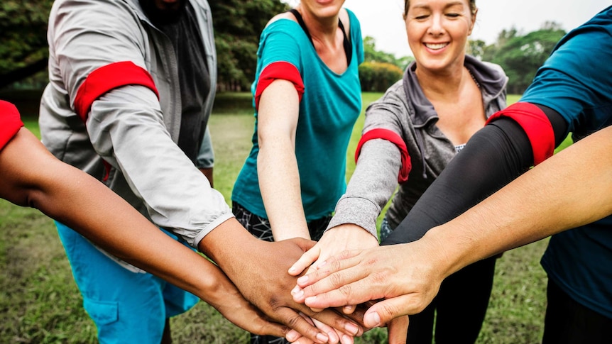 A group of people putting their hands together