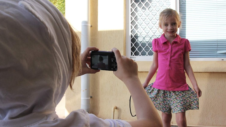 a little girl posing for a photo