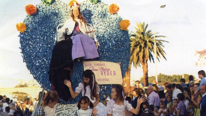 An old photo shows the Jacaranda Queen sitting on a home-made thrown while riding a float through the festival.