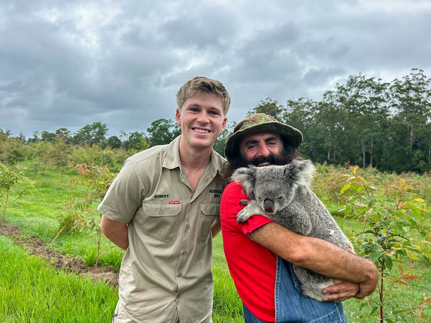 Costa holding a koala with Robert Irwin at Australia Zoo.