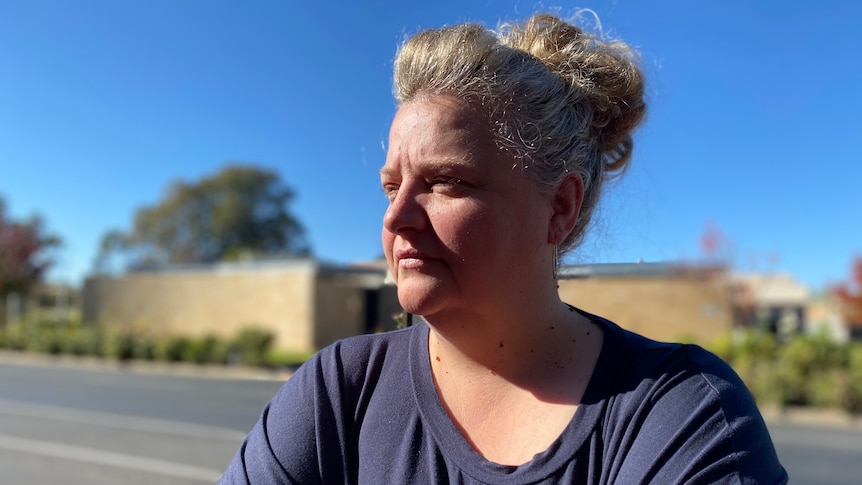 Woman standing in front of a road looking away from the camera 