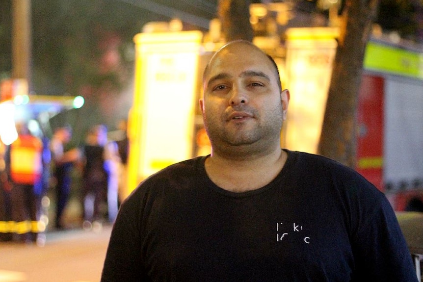 A man stands in front of a fire truck.