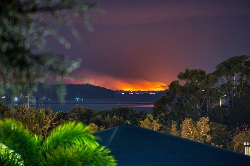 An orange blaze over the horizon at night time.