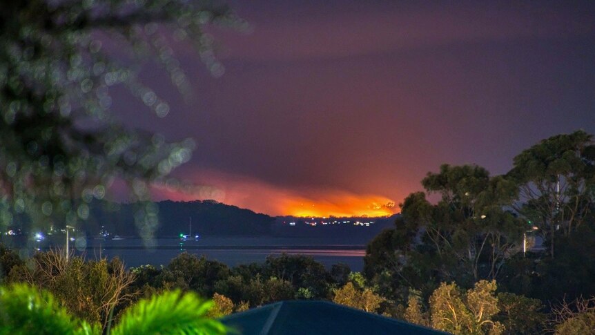 An orange blaze over the horizon at night time.