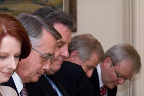 Australian Prime Minister Julia Gillard and members of her front bench bow their heads as they are sworn in (Getty Images: Co...