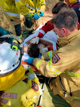 a man is on a stretcher, surrounded by emergency services