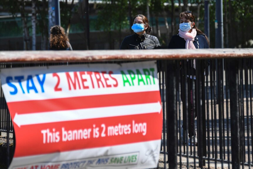 A banner reads "stay 2 metres apart. This banner is 2 metres long"
