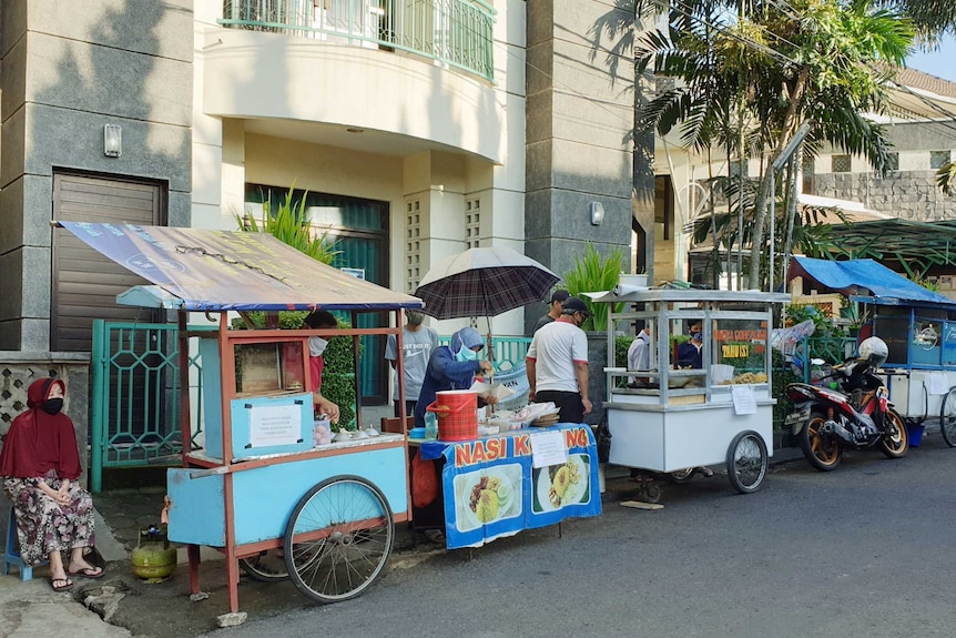A row of street food sellers outside a building