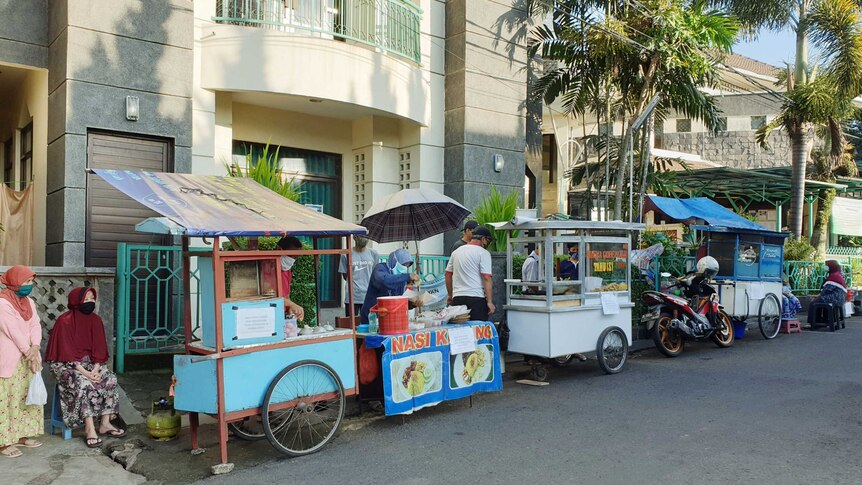 A row of street food sellers outside a building