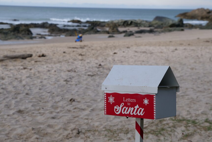 A letter box on a beach with the writing 'Santa letters'.