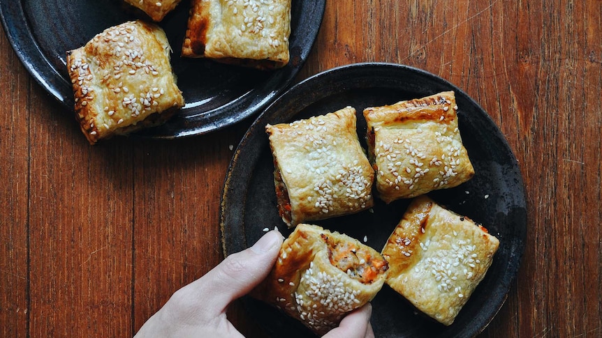 Two plates of bite-sized chicken and vegetable sausage rolls topped with sesame seeds, a fun family dinner recipe.