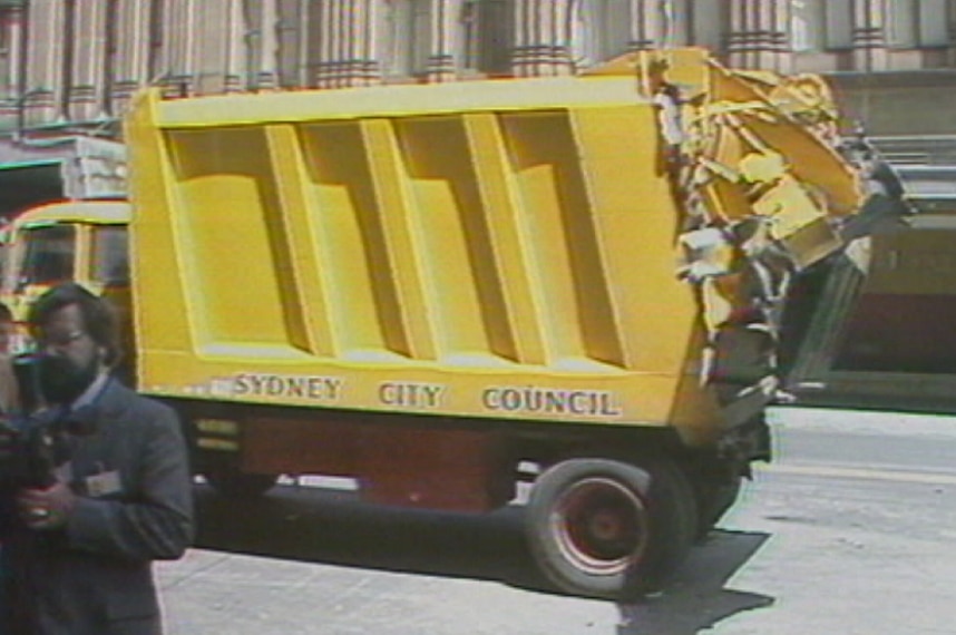 A large yellow rubbish truck.