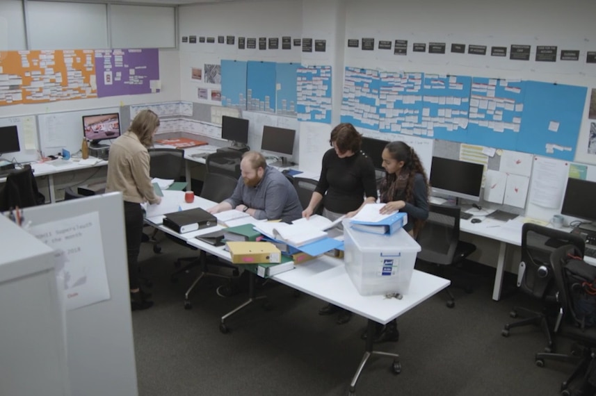 Room full of notes and posters with people working on Keli Lane case