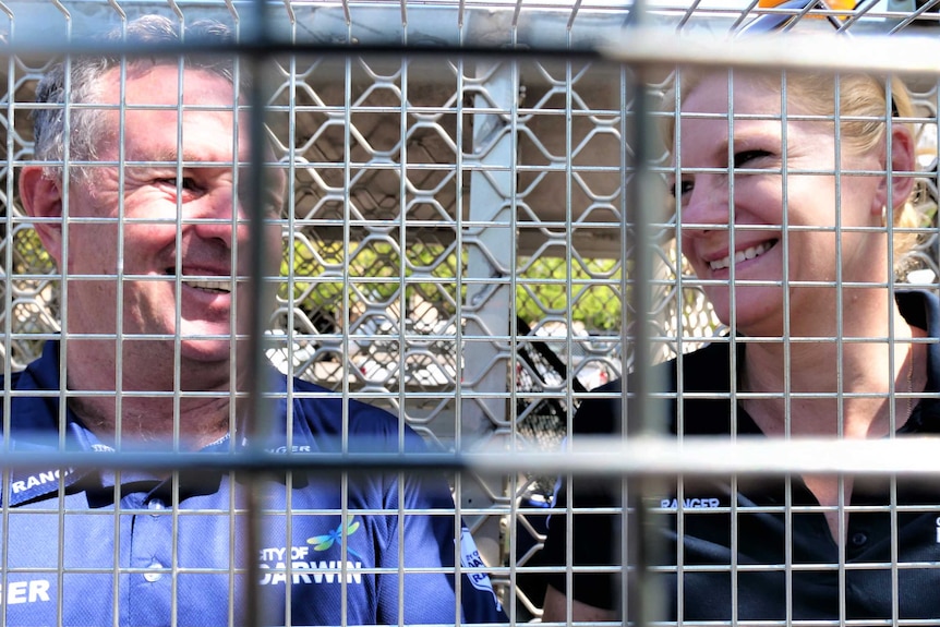 City of Darwin ranger Travis Sushames and animal education officer Samantha Overall with a cat trap