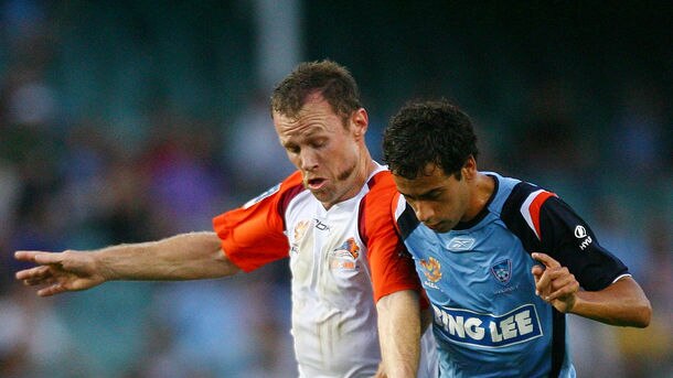 Roar midfielder Stuart McLaren and Sydney FC striker Alex Brosque compete for possession