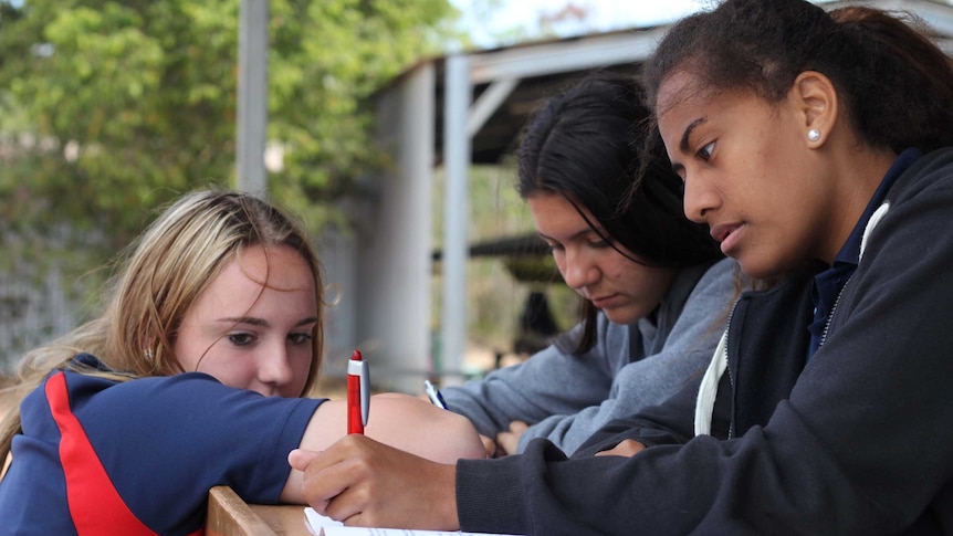 Three teenage girls with textbooks.