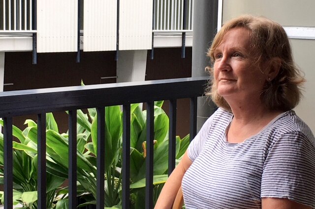 Sue sits on a balcony.