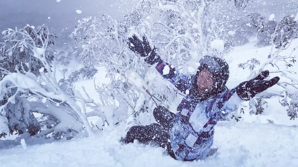 A woman throws snow in Thredbo