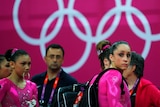 Larry Nassar stands behind members of the US gymnastics team.